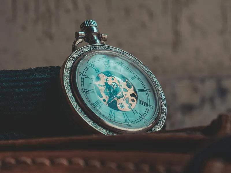 A detailed close-up of a classic vintage pocket watch with Roman numerals, showcasing intricate craftsmanship.