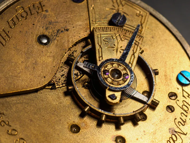 Intricate close-up of an antique brass watch mechanism with visible gears.